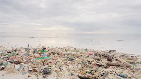 Microplastics and plastic trash on a beach with sea water in background Stock Footage 337333385