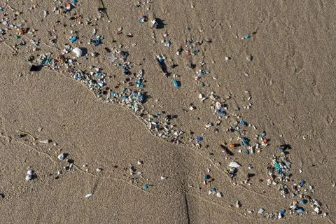 Microplastics polluting sand on the beach, environmental disaster 스톡 사진