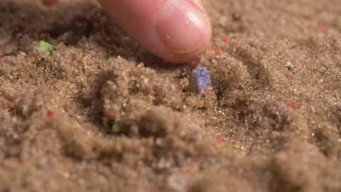 Microplastics on sandy beaches, tiny multicolored plastic bits in sand Video stock 155159404
