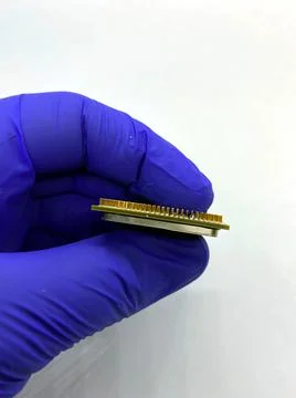 Microprocessor kept in hand covered by glove side closeup view isolated on wh 스톡 사진