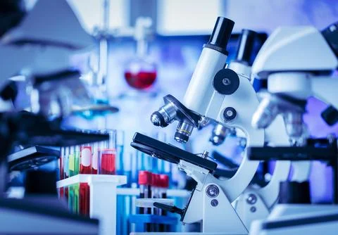 Microscope in and laboratory and test tube equipment in lab blue lights, sc.. Fotos de archivo