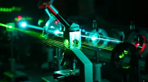 Microscope and multi-colored lasers passing in it in dark Stock Footage 12169874