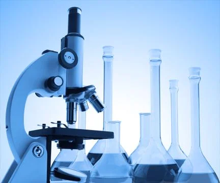 Microscope and test tubes with liquid toning in blue color Fotos de archivo