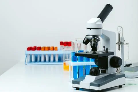 Microscope and test tubes on table in laboratory, close up Stock Photos