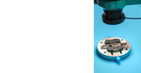 Microscope examining electronic circuit board on blue surface with clear focus Fotos de archivo