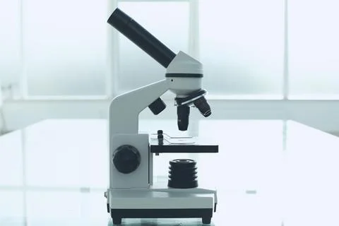 Microscope on a glass table in a bright room. Laboratory medical research Stock Photos