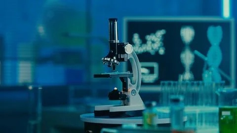 Microscope, glass test tubes and flasks on the background of a computer monitor Stock Photos