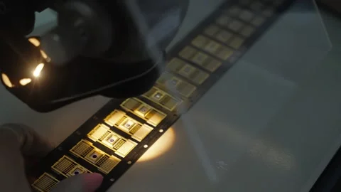 Microscope inspection of gold-plated semiconductor packages on carrier tape Stock Footage 325976695
