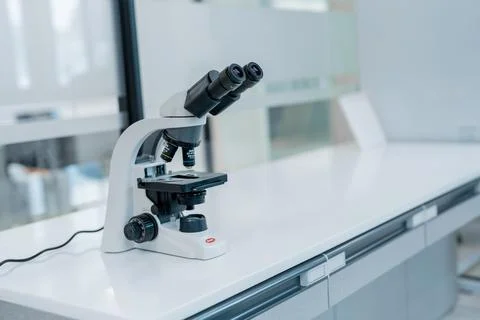 Microscope on a lab table with a clean workspace during daytime Fotos Stock