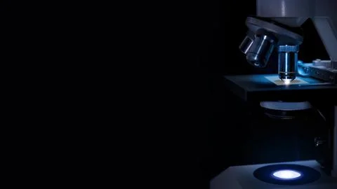 Microscope in labor in dark blue  light  and black background. Stock Photos