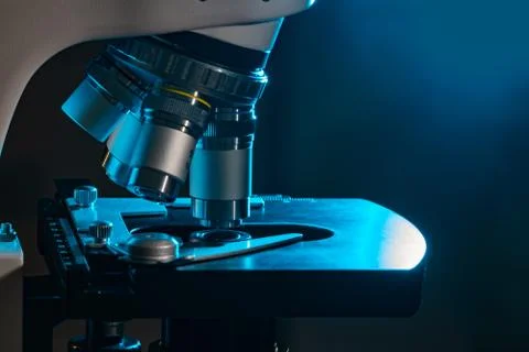 Microscope in laboratory at night. Microbiology and research concept. Stock Photos