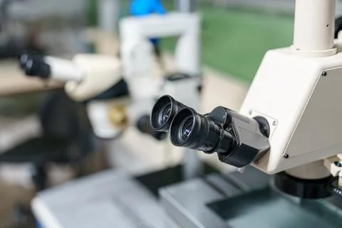 Microscope on laboratory table with blurred background and focus on optical.. 스톡 사진
