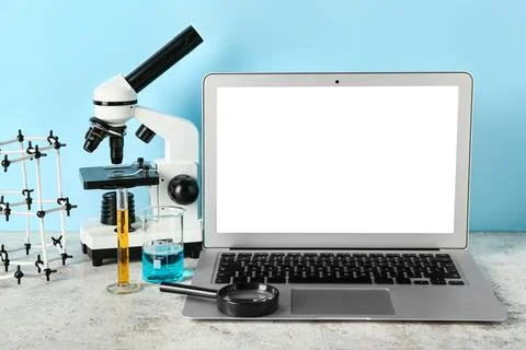 Microscope with laptop, molecular model and flasks of samples on blue backgro Stockfoto's
