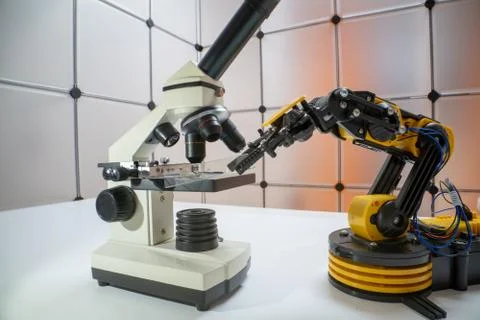 Microscope slide in robot arm and science microscope Stock-Fotos