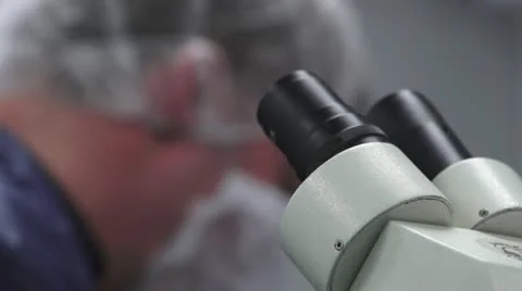 Microscope with Technician out of focus in background Stock Footage 10895365
