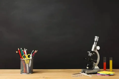 Microscope with test tubes and stationery on wooden desk Stock-Fotos