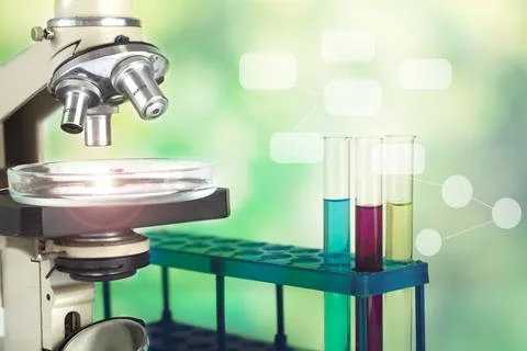 Microscope with test tubes on a green background. Stock Photos