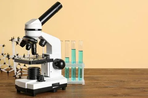 Microscope with test tubes of samples and molecular model on wooden table aga Photos