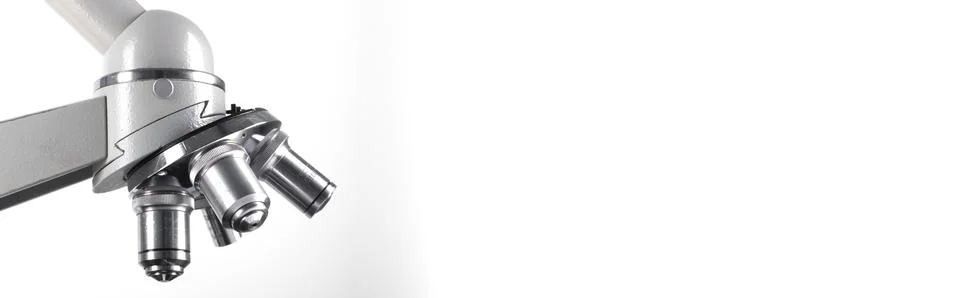A microscope with three lenses on a white background. Stock Photos
