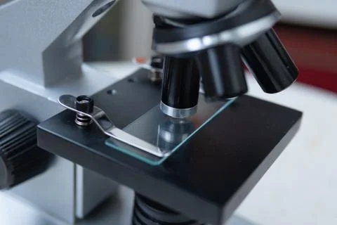 Microscope on white and red background close frame Stock Photos