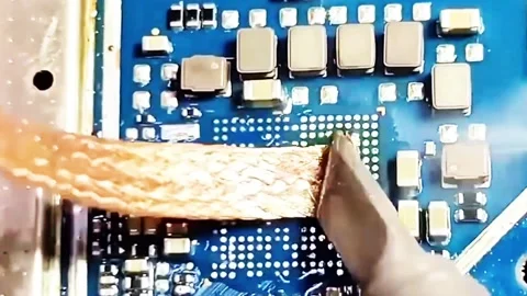Microscopic View of Cleaning Mobile Phone Motherboard with Desoldering Wick Stock Footage 332981140