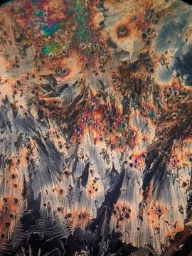 Microscopic view of colorful crystal formations under polarized light, show.. Stock Photos