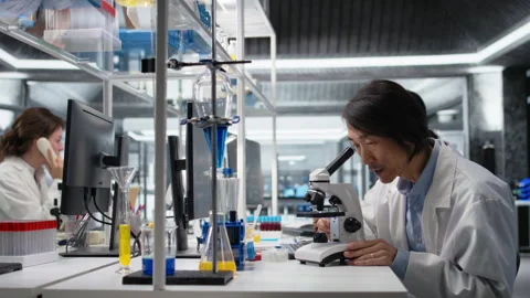 Microscopist uses compound microscope to study genetic material Stock Footage 320146335