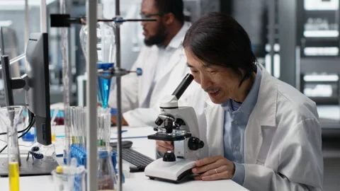 Microscopist uses compound microscope to study genetic material Stock Footage 320724778