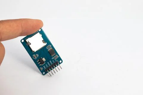 A microSD card reader module held by a finger. This module is used for electr Stock Photos