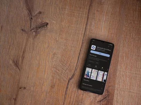 Microsoft 360 app play store page on smartphone on wooden background Stock Photos