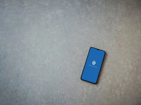 Microsoft Authenticator app launch screen with logo on the display of a black Stock Photos