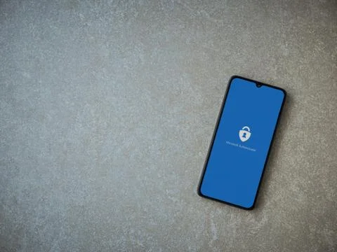Microsoft Authenticator app launch screen with logo on the display of a black Stock Photos