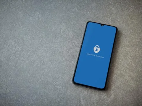 Microsoft Authenticator app launch screen with logo on the display of a black Stock Photos