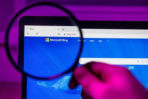 Microsoft Bing chatbot through magnifying glass on screen Stock Photos