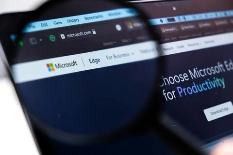 Microsoft Edge logo on the screen of laptop through magnifying glass Stock Photos