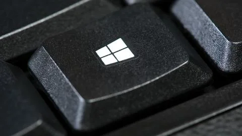Microsoft Windows OS logo, operating system key on a simple black desktop P.. Foto stock