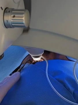 Microsurgery procedure using surgical scissors under microscope Stock Photos