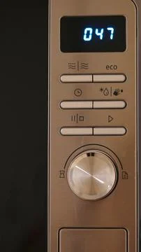 Microwave control panel with digital display and various function buttons Stock Photos
