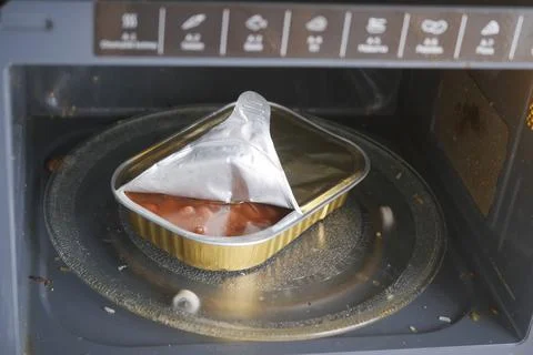 Microwave cooking with metal container inside Stock Photos