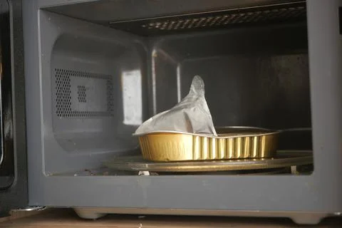 Microwave with a metal container inside during cooking Stock Photos