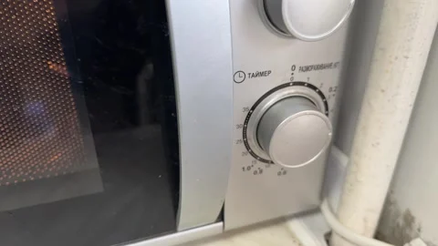 Microwave oven control knob and front panel in close up, kitchen appliance Stockbeeldmateriaal 337117948