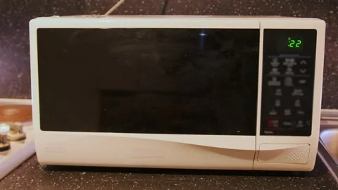 Microwave oven running with timer on display close-up, appliance heating food Stock Footage 333478861