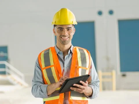 Mid adult construction worker using digital tablet, portrait Stock Photos