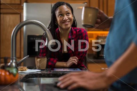 Mid Adult Couple At Kitchen Counter With Digital Tablet