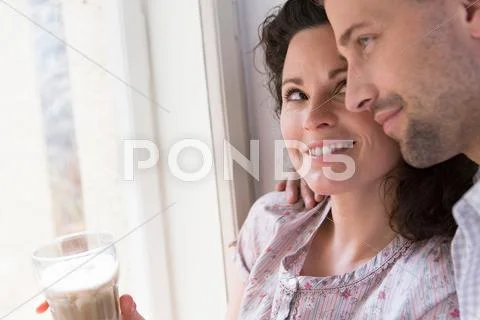 Mid Adult Couple Sitting At Window