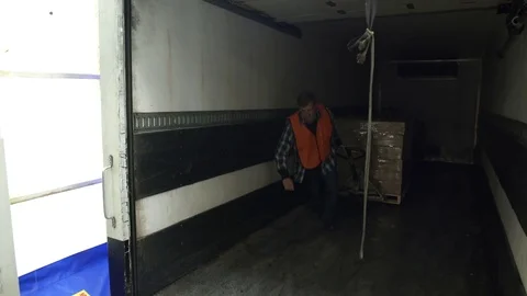 Mid adult man pulling boxes into a warehouse Stock Footage 83395694