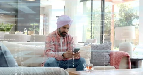 Mid-adult man sofa tapping phone, browsing tech, binary overlay appearing, Stock Footage 321301871