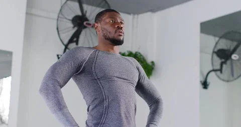 Mid adult man taking deep breath, hinging hips, folding to stretch in gym Stock Footage 340674864