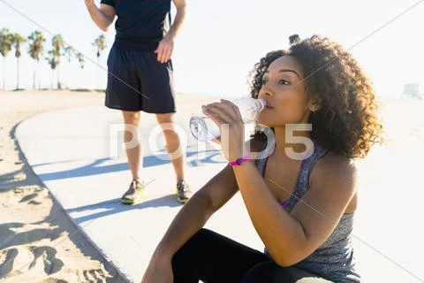 Mid Adult Woman, By Beach, Drinking From Water Bottle