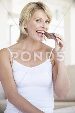 Mid Adult Woman Eating Chocolate Stock Photos